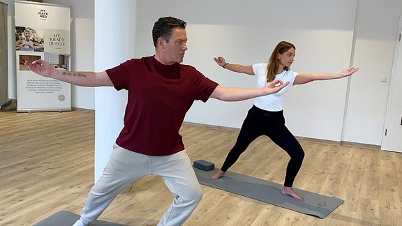 Ein Mann und eine Frau beim Yoga