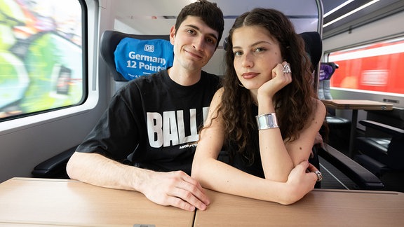 Abor und Tynna sitzen in einem ICE der Deutschen Bahn.