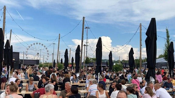 Viele Fans sitzen in der Außengastronomie in der Adele World. Ein Hauch von Oktoberfest in der Adele World vor dem Konzert des Superstars Adele
