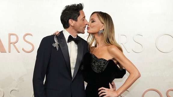 Adrien Brody und Georgina Chapman küssen sich auf dem roten Teppich