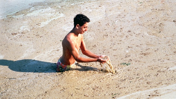 Der bräunliche, schmierige Algenschaum kann diesen jungen Mann nicht von einem Bad im Meer bei Romagno abhalten, aufgenommen im Juli 1989.