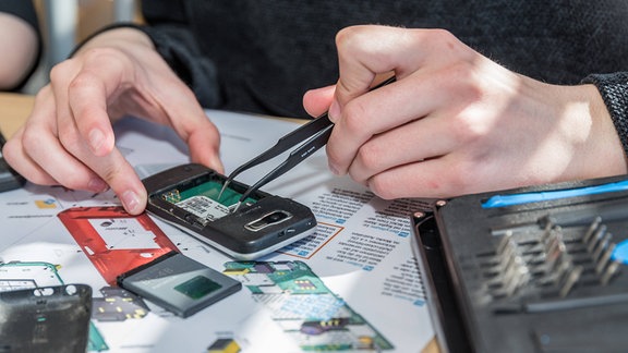Techniker zerlegt altes Handy.