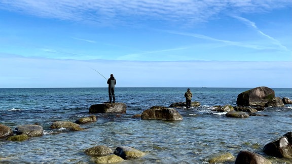 Zwei Männer angeln an der Küste