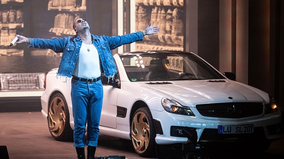 Der deutsche Rapper und Sänger Apache 207 steht bei seinem Auftritt in der Waldbühne vor einem Mercedes SL.