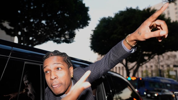 A$AP Rocky gestikuliert aus dem Fenster eines Fahrzeugs, während er das Gericht verlässt, nachdem er in seinem Prozess für nicht schuldig befunden wurde.
