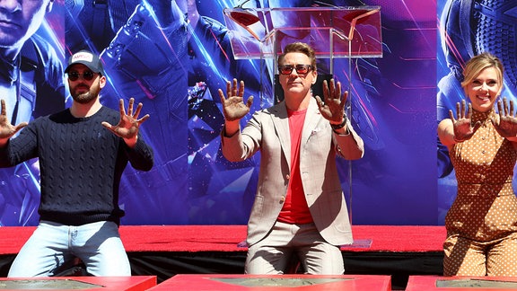 Chris Evans (l-r), Robert Downey Jr. und Scarlett Johansson, Schauspieler des Films "Avengers: End Game", hinterlassen bei einer Hand- und Fußabdruckzeremonie im TCL Chinese Theatre ihre Spuren in frischem Beton.