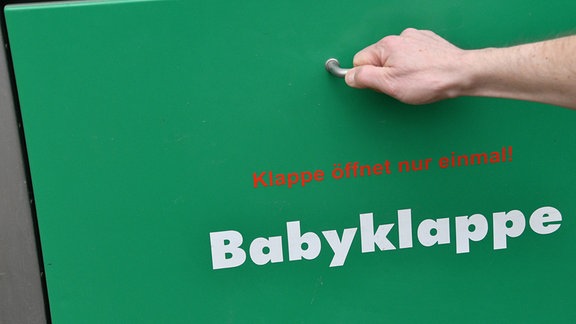 Eine Hand greift nach der erneuerten Babyklappe am St. Josefs-Krankenhaus. (zu "Vertrauliche Geburt: Hilfe für Frauen in Not")