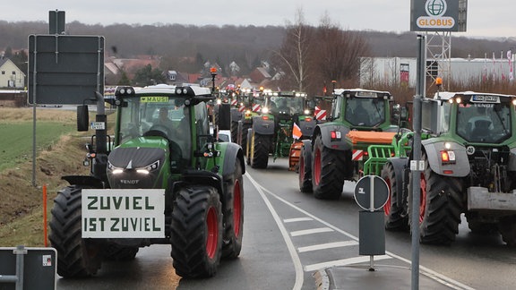 Landwirte fahren mit ihren Traktoren über die Bundesstraße 7. 