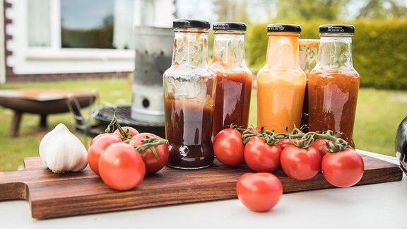 Verschiedene Grillsaucen stehen 2021 auf einem Gartentisch bereit 