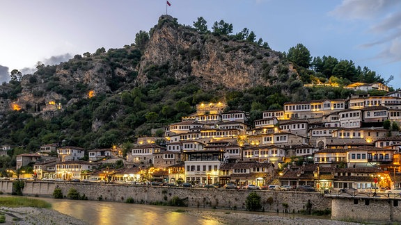 Lichter brennen am Abend in den Häusern von Berat Altstadt in Albanien.