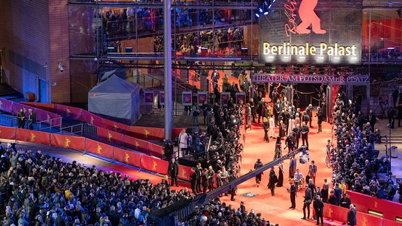 Erste Gäste stehen während der Eröffnung der 74. Berlinale auf dem roten Teppich vor dem Berlinale-Palast.
