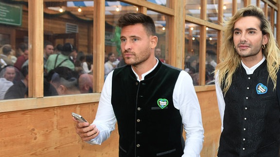 Bill Kaulitz (r), Sänger der Band Tokio Hotel, und Model Marc Eggers verlassen das Schützenzelt auf der Wiesn.