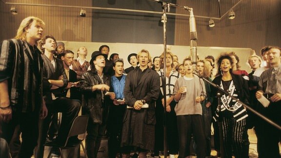 Menschen stehen bei einander und singen.