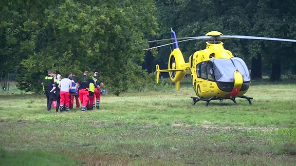 Rettungskräfte vor Rettungshubschrauber