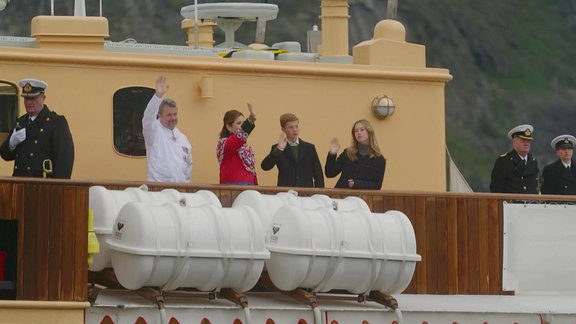 Frederik und seine Familie winken von einem Schiff.