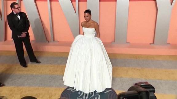 Kim Kardashian vor einer Veranstaltung im weißen Kleid.