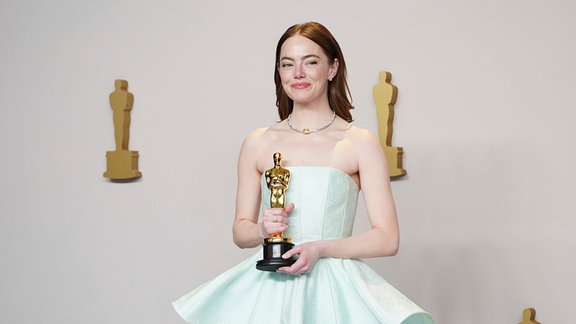 Emma Stone posiert im Presseraum mit dem Preis für die beste Leistung einer Schauspielerin in einer Hauptrolle für "Poor Things" bei der Oscar-Verleihung