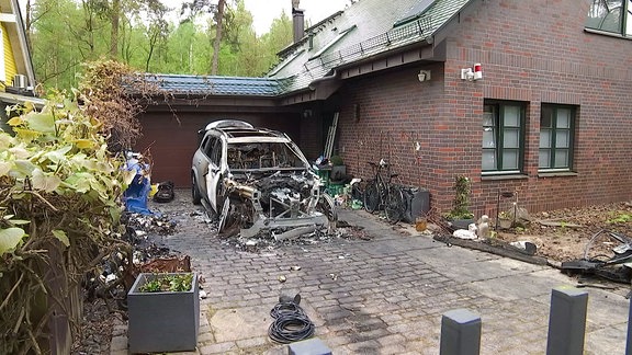 Ein verbranntes Auto neben einem Wohnhaus