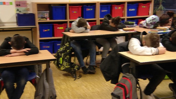 Schüler habe ihren Kopf auf der Schulbank