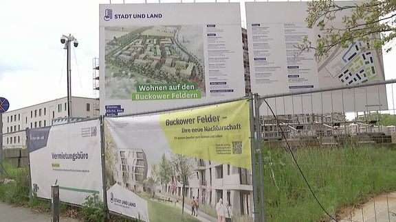 An Bauzäunen hängen Plakate.