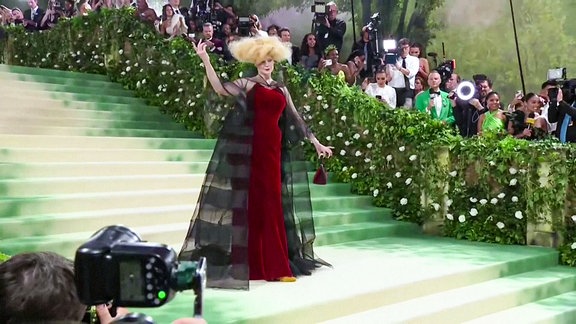 Eine Frau im Designerkleid auf einer Treppe