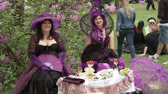 zwei Frauen sitzen im Park an einem Tisch