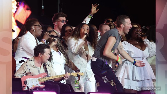 Michael J Fox spielt Gitarre bei einem Konzert der Band Coldplay in Glastonbury. 