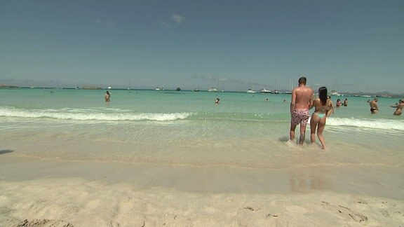 Strandblick aufs Wasser mit zahlreichen Badegästen