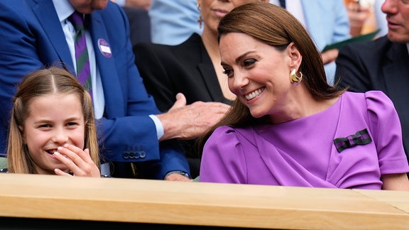 Kate, Prinzessin von Wales und Prinzessin Charlotte sitzen auf einer Tribüne und lachen.