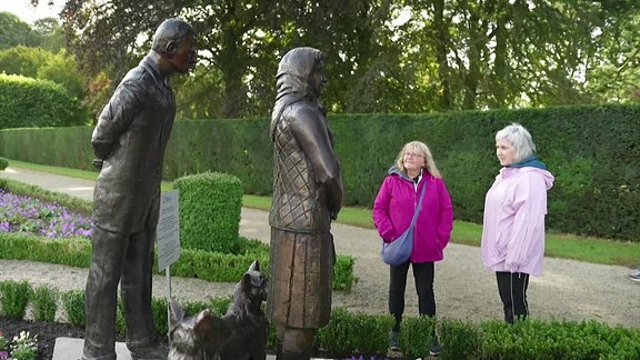 Besucher stehen vor einer Statue