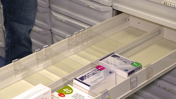 offenes Fach mit wenigen Packungen Medikamenten
