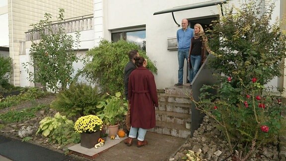 Zwei Paare stehen an einem Haus