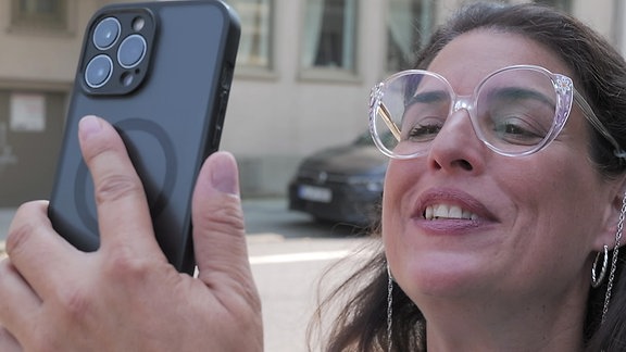 Elena Uhlig schaut auf ein Handy.