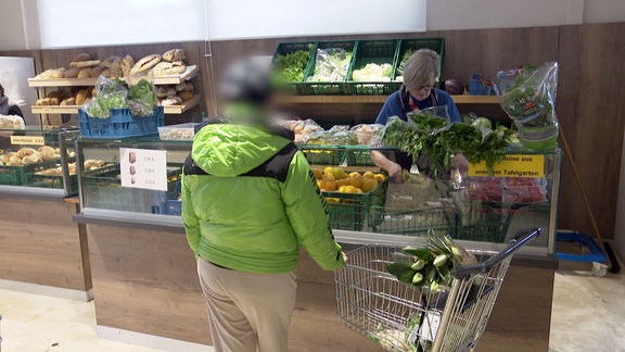 Frau bekommt Gemüse ausgehändigt.