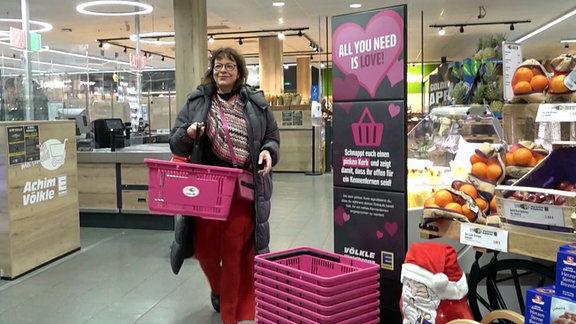 Frau mit rosa Warenkorb im Supermarkt