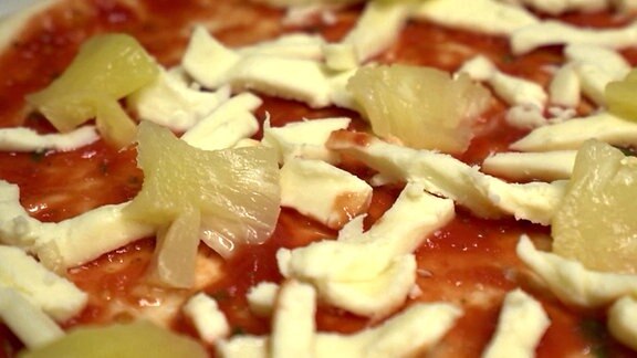Nahaufnahme auf den Belag einer Pizza Hawaii