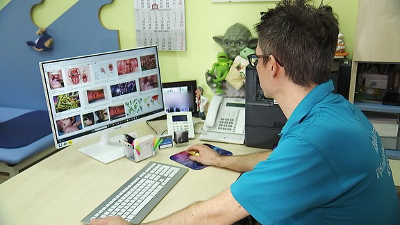 Ein Arzt sitzt am Computer.