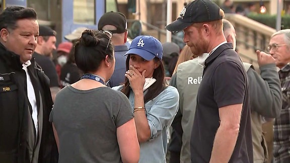 Meghan und Prinz Harry sprechen mit einer Frau.