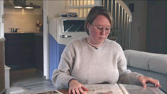 Eine Frau blättert in einem Aktenordner