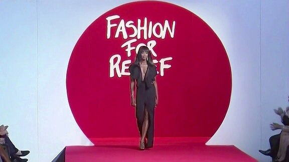 Naomi Campbell auf dem Laufsteg. Im Hintergrund das Logo: Fashion for relief