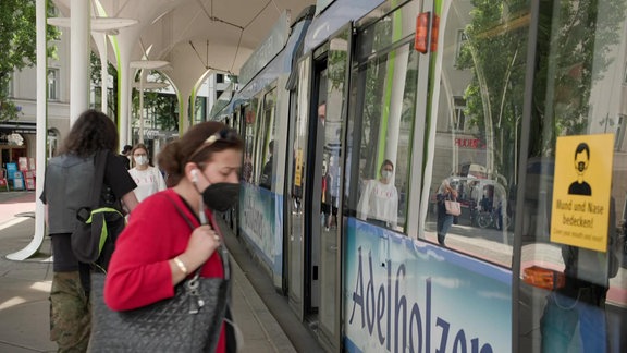 Eine Frau an einer Bahnhaltestelle