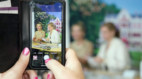 Ein Smartphone fotografiert eine Autogrammstunde