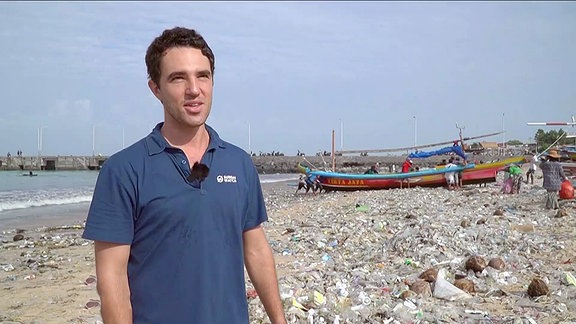 Ein Umweltaktivist im Interview an einem Müllstrand