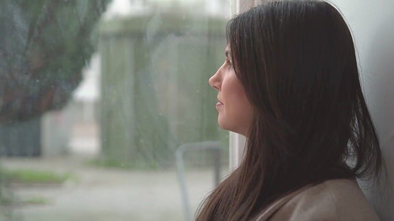 Eine Frau sieht aus dem Fenster