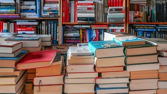 Gestapelte Bücher und Bücherregal