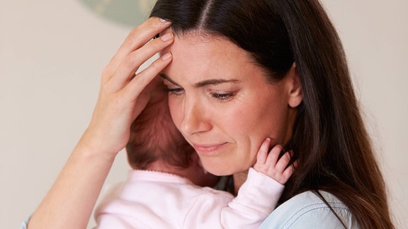 Eine Frau hält ein Baby im Arm