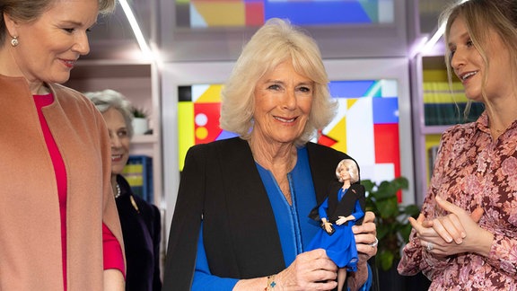 Königin Camilla (M) von Großbritannien, Präsidentin von Women of the World (WOW), erhält während eines Empfangs zur Feier des Internationalen Frauentags und zum Abschluss der WOW-Girls-Festival-Bustour im Buckingham-Palast eine Barbie-Puppe in ihrem Outfit als Anerkennung für ihre Arbeit zur Unterstützung von WOW.