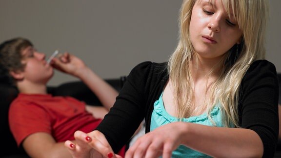 Mädchen dreht Joint, Junge raucht