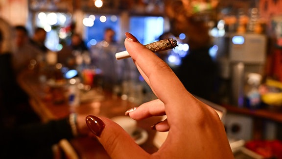 Eine Frau raucht einen Joint in einem Coffeeshop in Amsterdam.