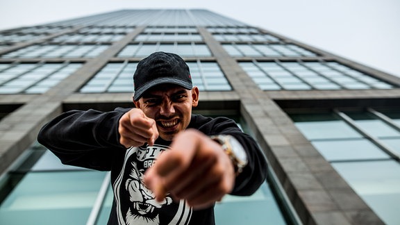 Der Rapper Capital Bra vor einem Hochhaus